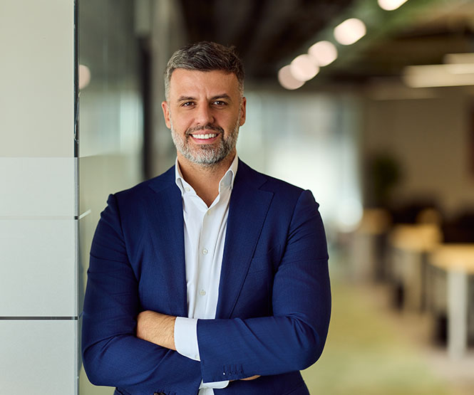 Business man leaning up against wall in office