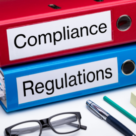 stack of binders for compliance and regulation