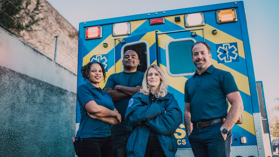 Team of EMS and Ambulance workers in front of ambulance truck.